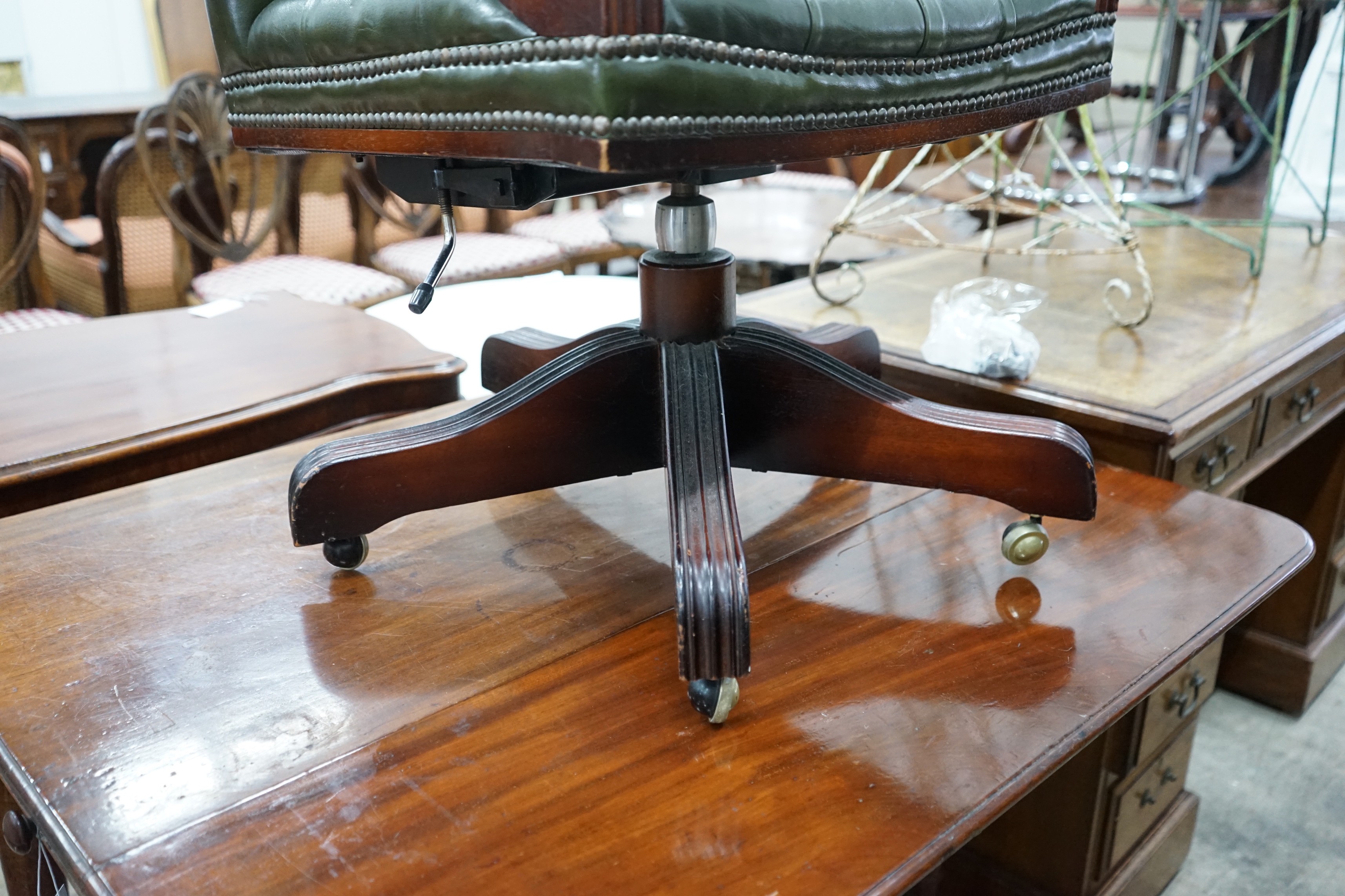 A reproduction mahogany and buttoned green leather swivel desk chair, width 56cm, depth 51cm, height 94cm